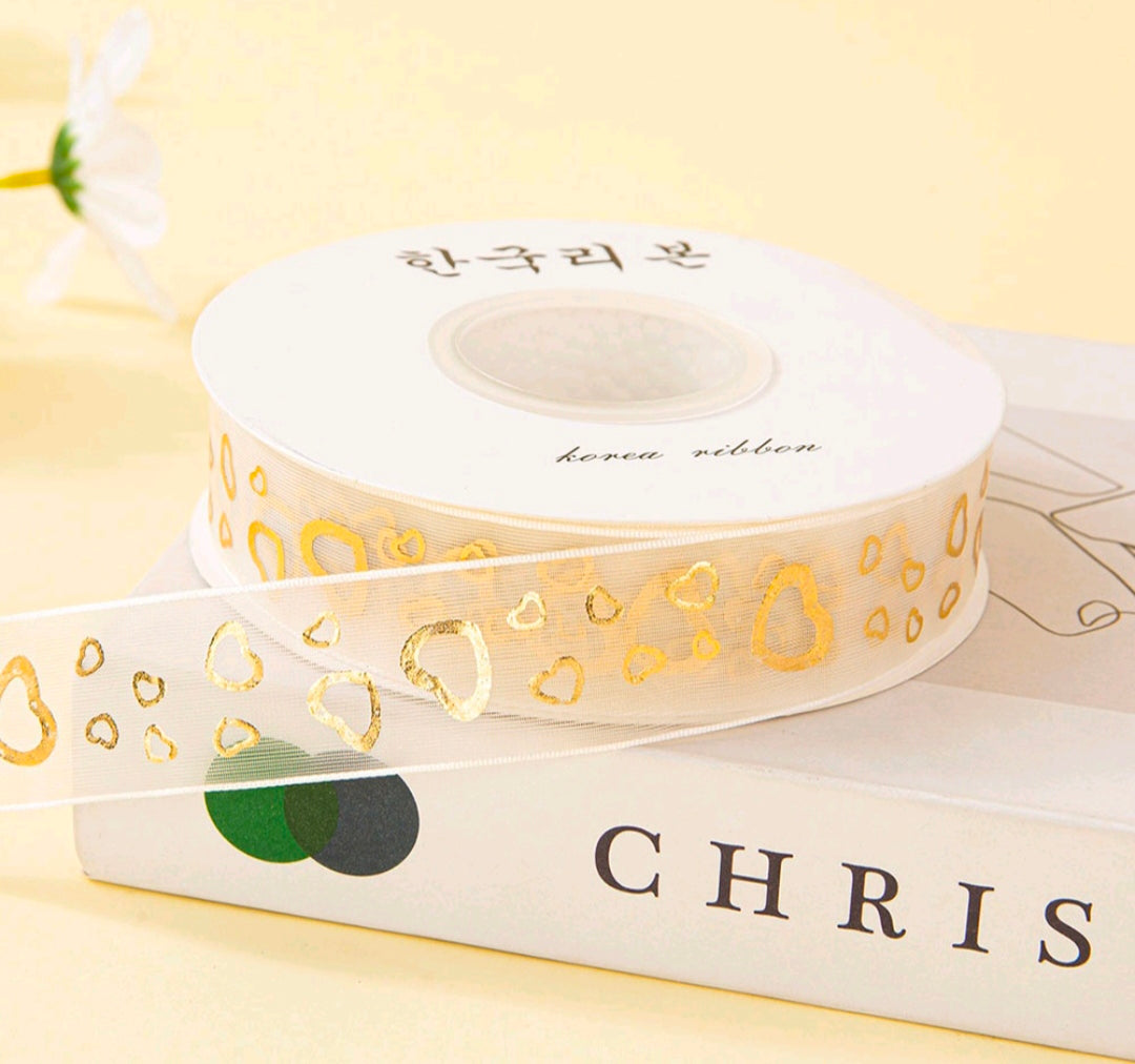 White ribbon spool with gold heart pattern print, 2.5 cm wide