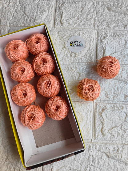 Rakhi thread roll with peach orange thread balls in open box and loose ball