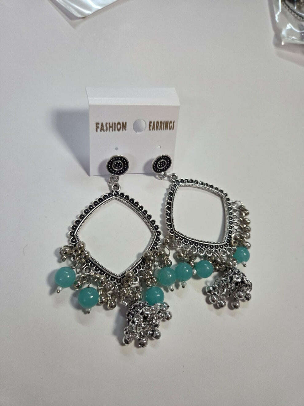 Square jhumka earrings with turquoise/light-blue beads and silver-tone bell fringe