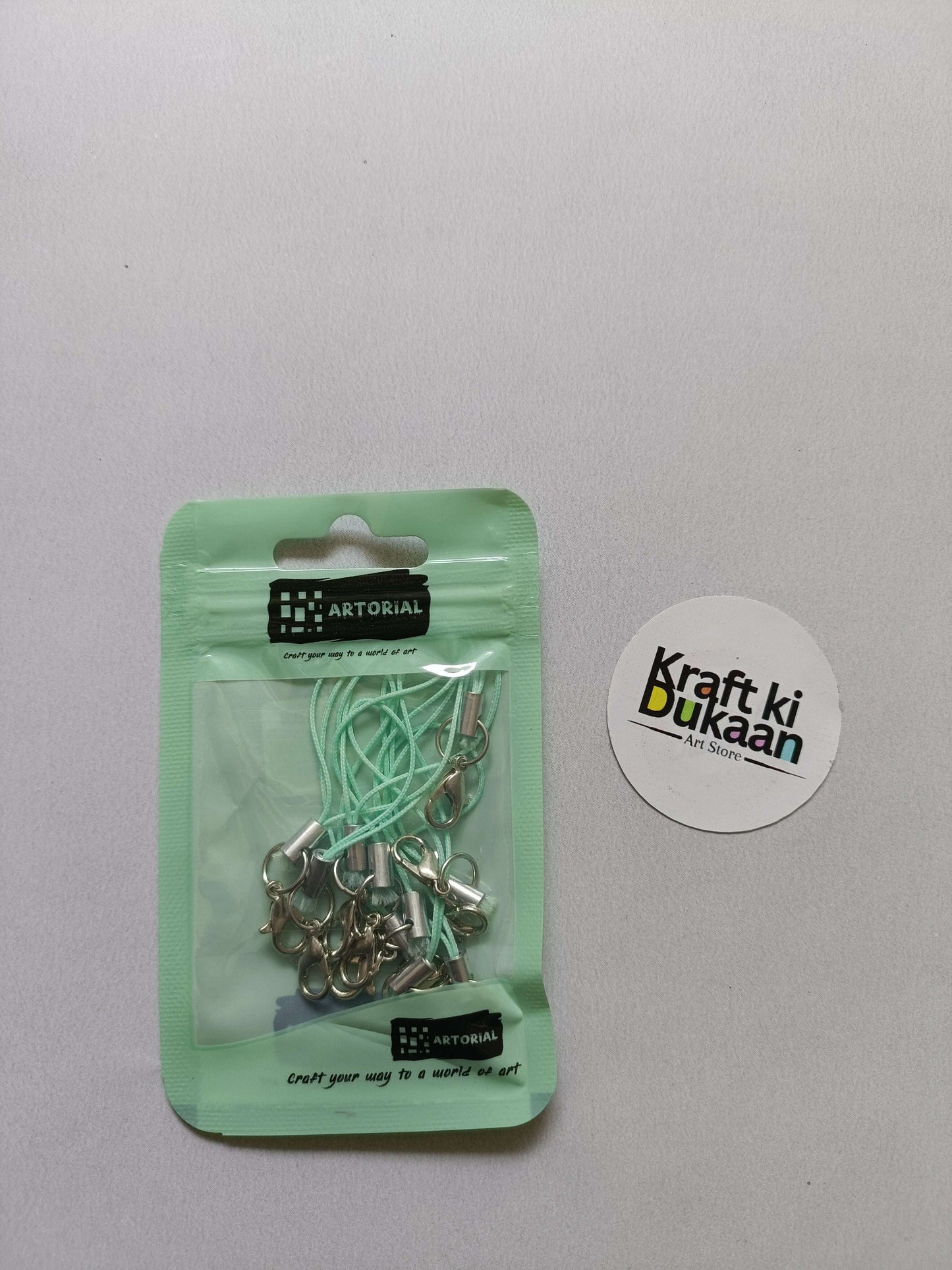 Light green cord keychain set with lobster clasps, metal clips on a card pack.