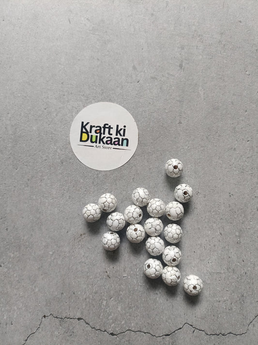 Rakhi bracelet beads pack with round white soccer-ball patterned beads laid out