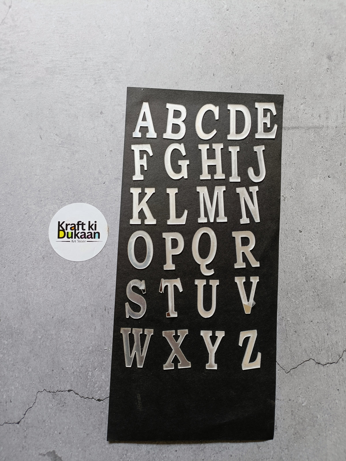 Acrylic alphabet set with silver-tone cutout letters A–Z on a dark plaque