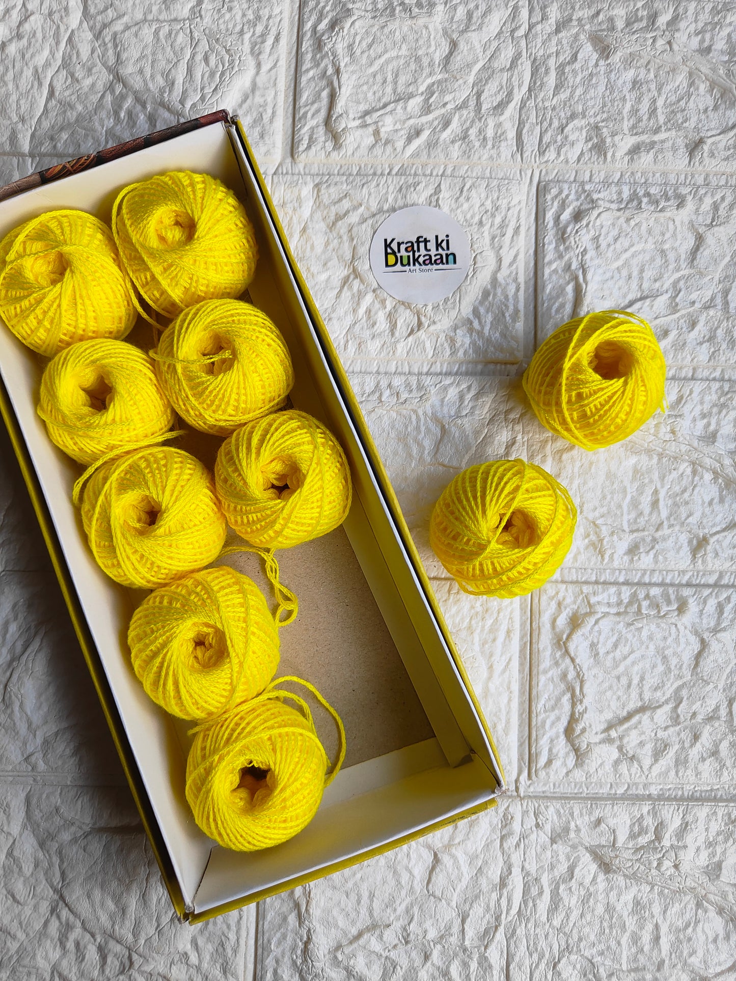 Rakhi thread roll with bright yellow-green thread balls in open box