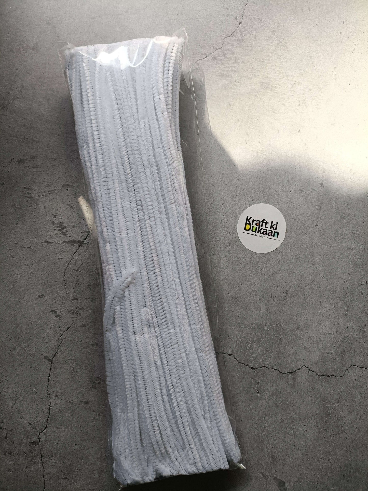 White pipe cleaners bundle in clear packaging, fuzzy chenille texture.