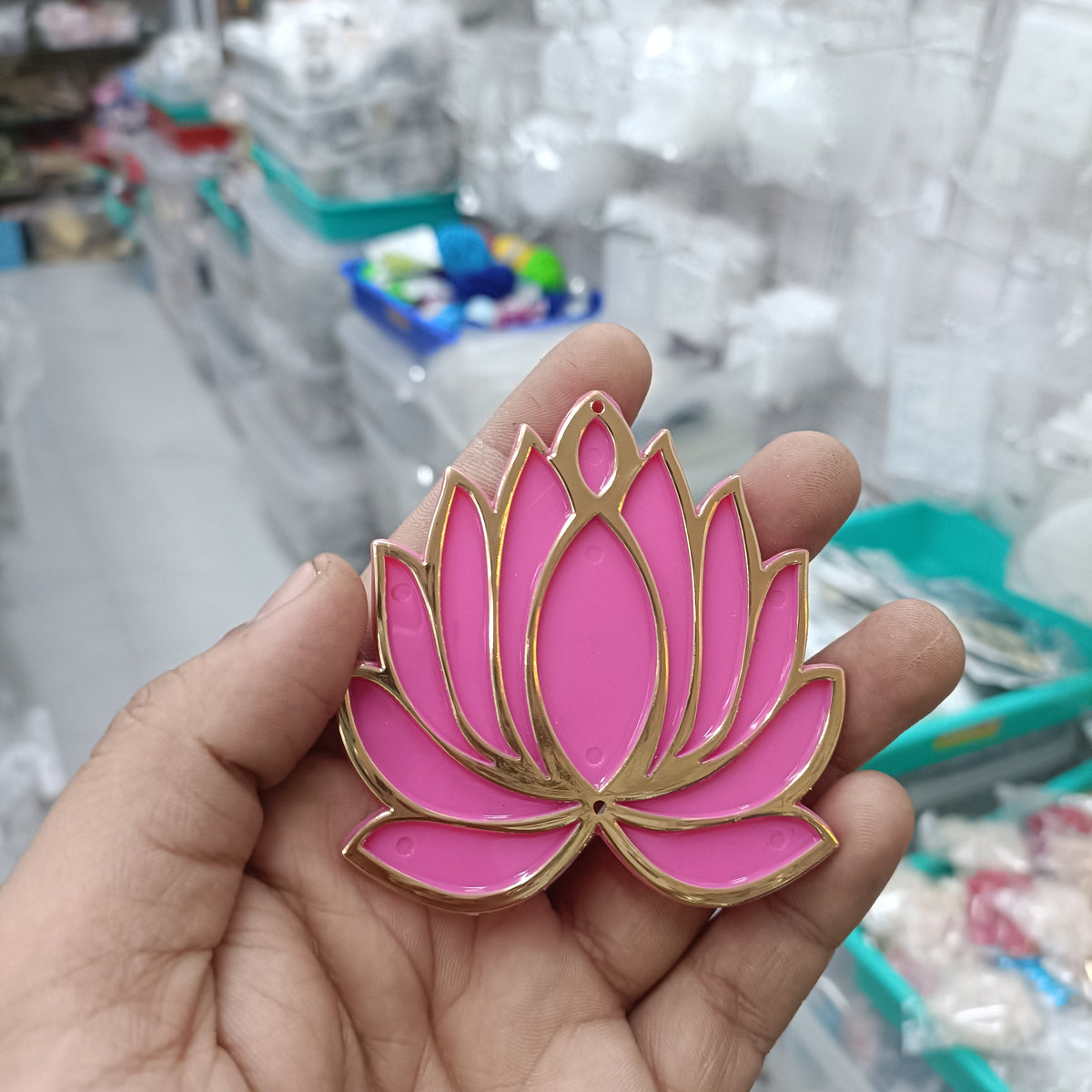 Pink lotus acrylic tea light holder with gold trim, shown in hand