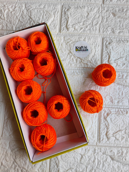 Rakhi thread roll with orange thread balls in open box and one loose ball