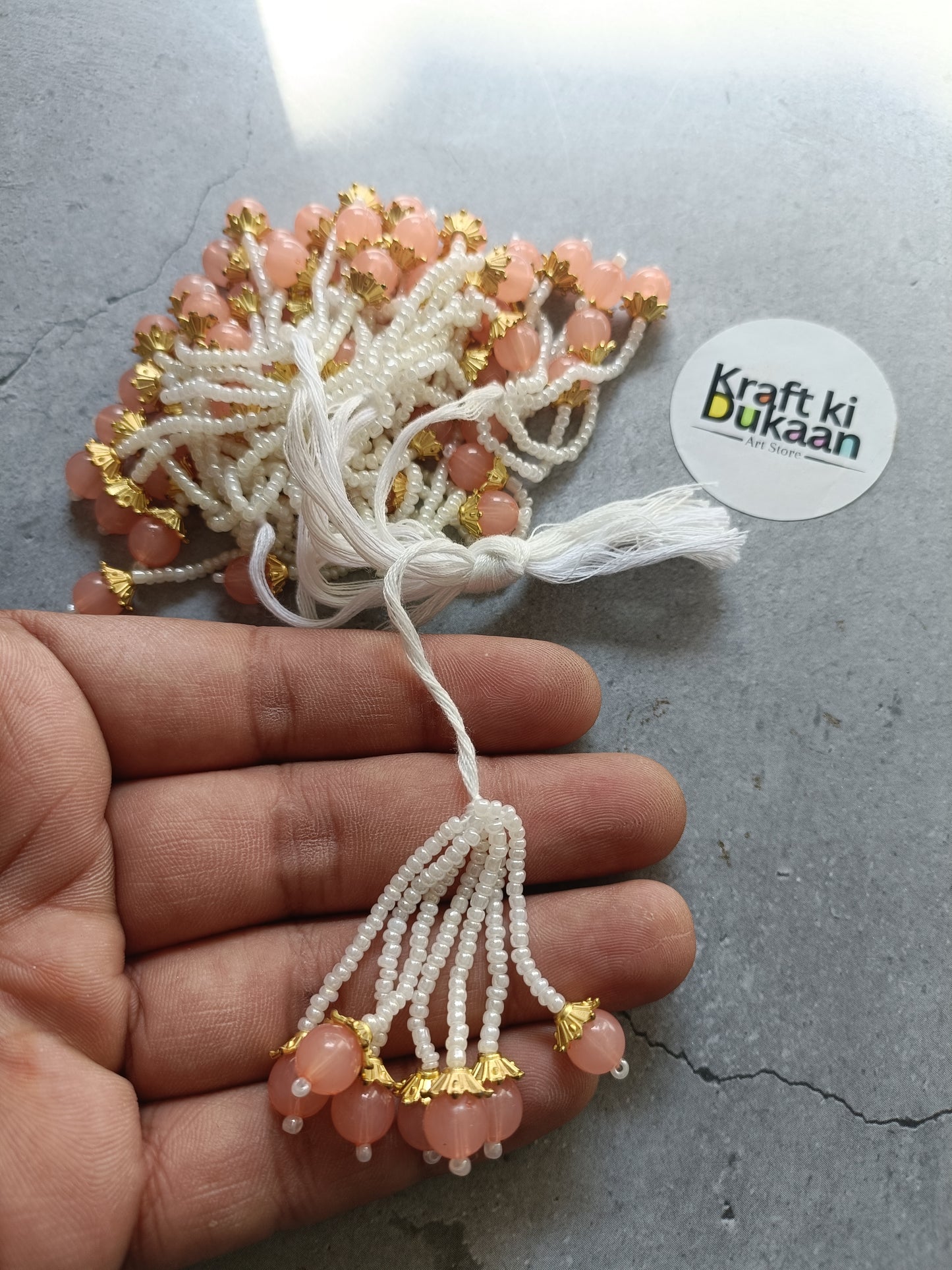 Peach bead tassel latkan with white thread and gold accents