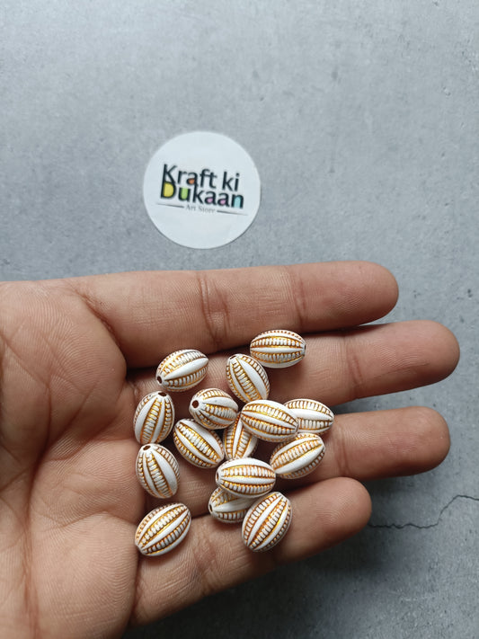 Rakhi bracelet bead set, oval white-and-gold striped beads (25) in hand