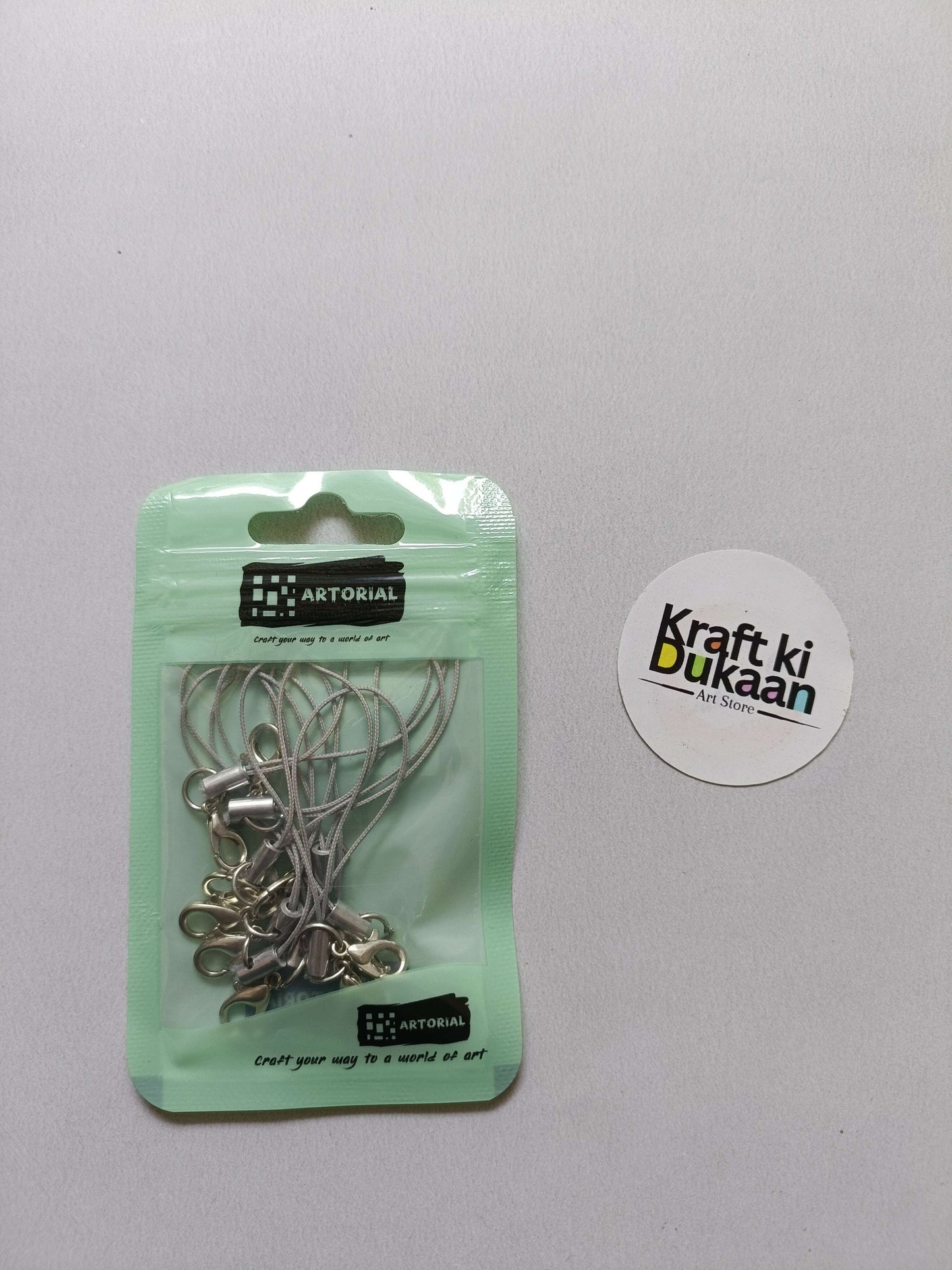 Gray cord keychain set with lobster clasps, metal clips on a card pack.