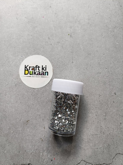 Hexagon glitter jar with silver glitter in a small white-lidded bottle