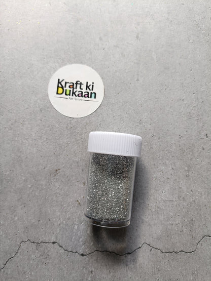 Silver chunky glitter powder in clear shaker bottle with white lid
