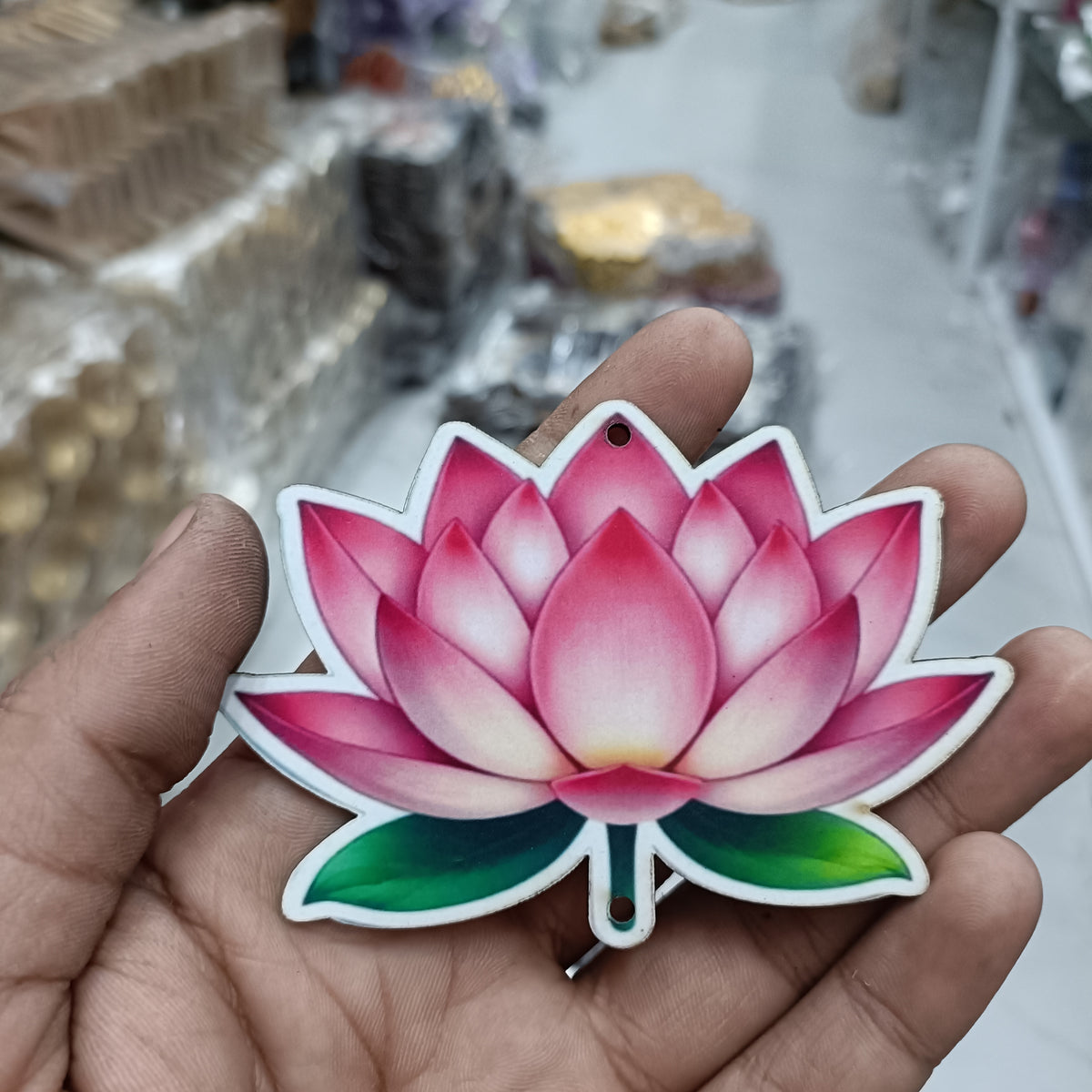 Pink lotus MDF cutout with green leaves, round hanging hole, close-up in hand