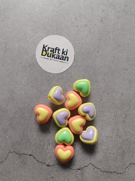 Heart-shaped rakhi bracelet beads in assorted pastel colors: pink, yellow, green, lavender