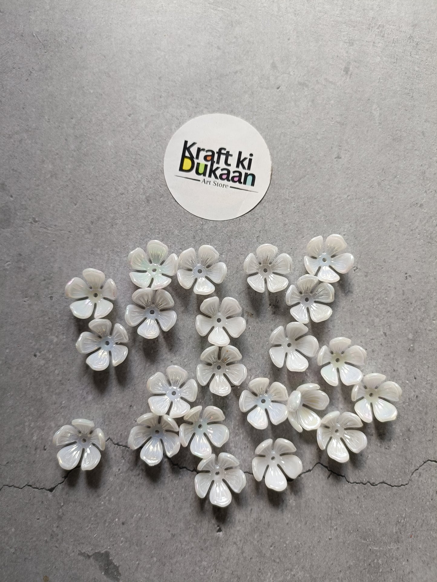 White flower-shaped beads scattered, small round petals with iridescent centers