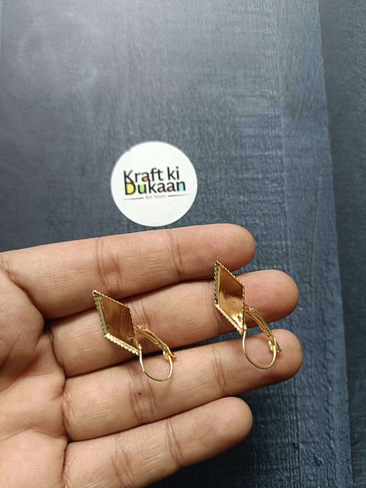 Pair of diamond earring bases on hand: gold-tone square settings with hoop hooks