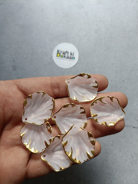 Flower leaf beads, white petal style with gold-tone edges on hand