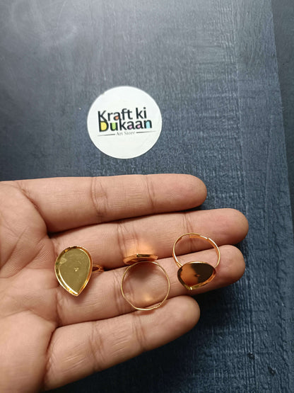 Gold-tone ring bases on fingers: oval, round, and square bezel open bands