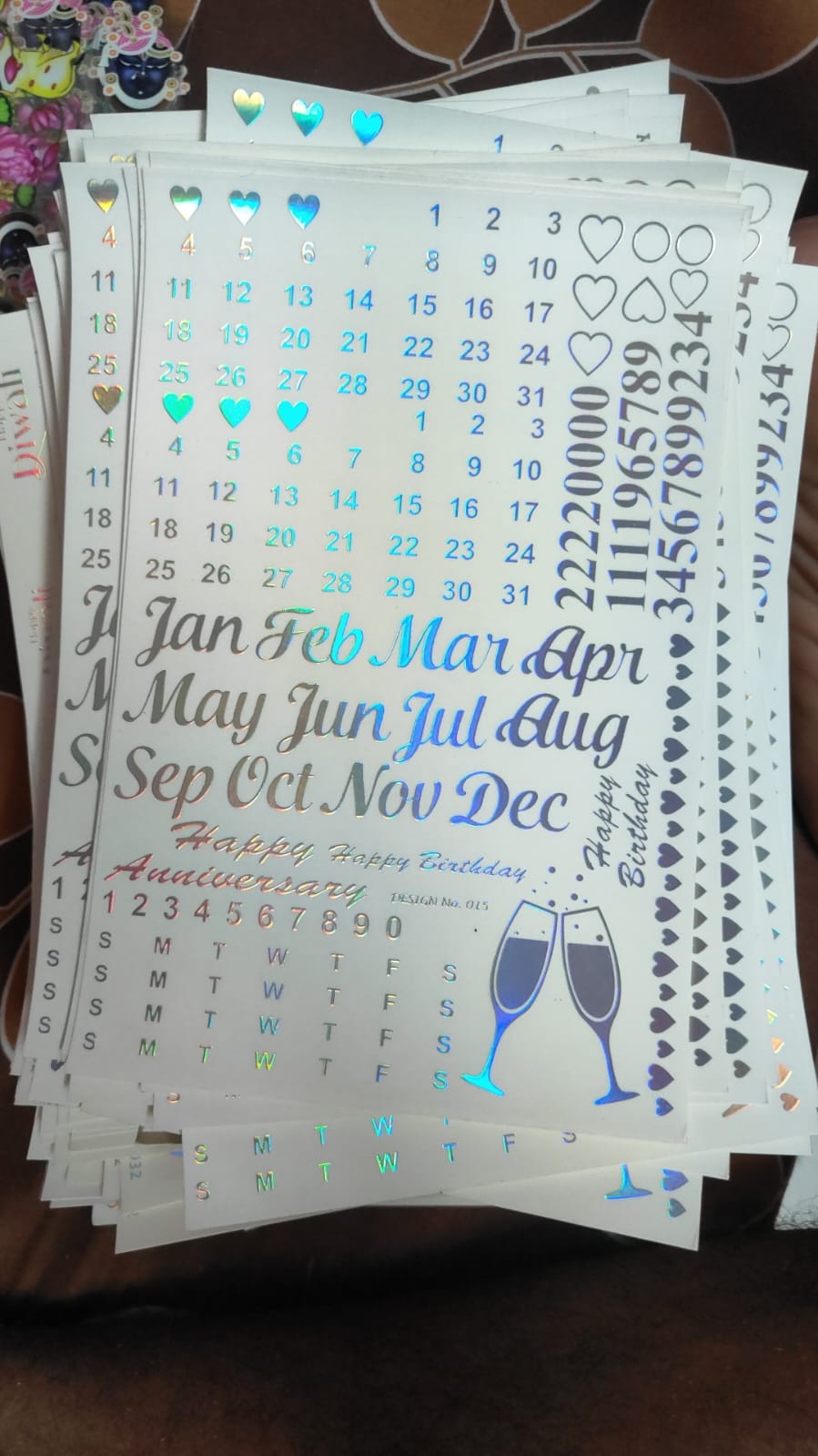 Holographic sticker sheet with script dates, heart icons, and champagne glass designs