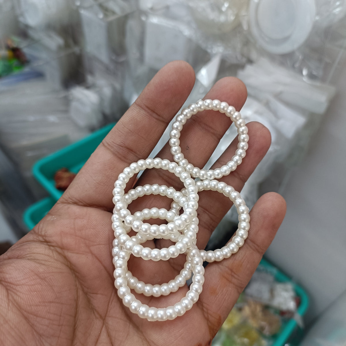 White pearl ring with small round beads forming a broad circular band