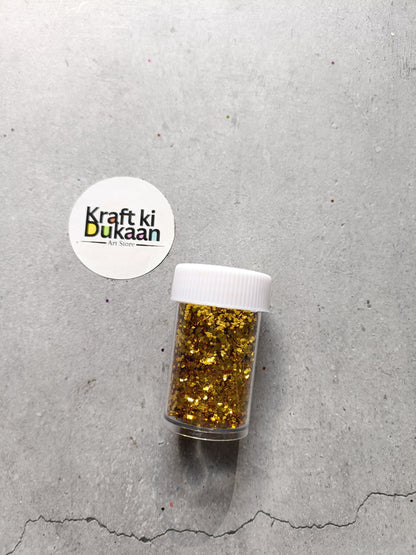 Hexagon-shaped glitter jar with gold glitter flakes and white screw lid