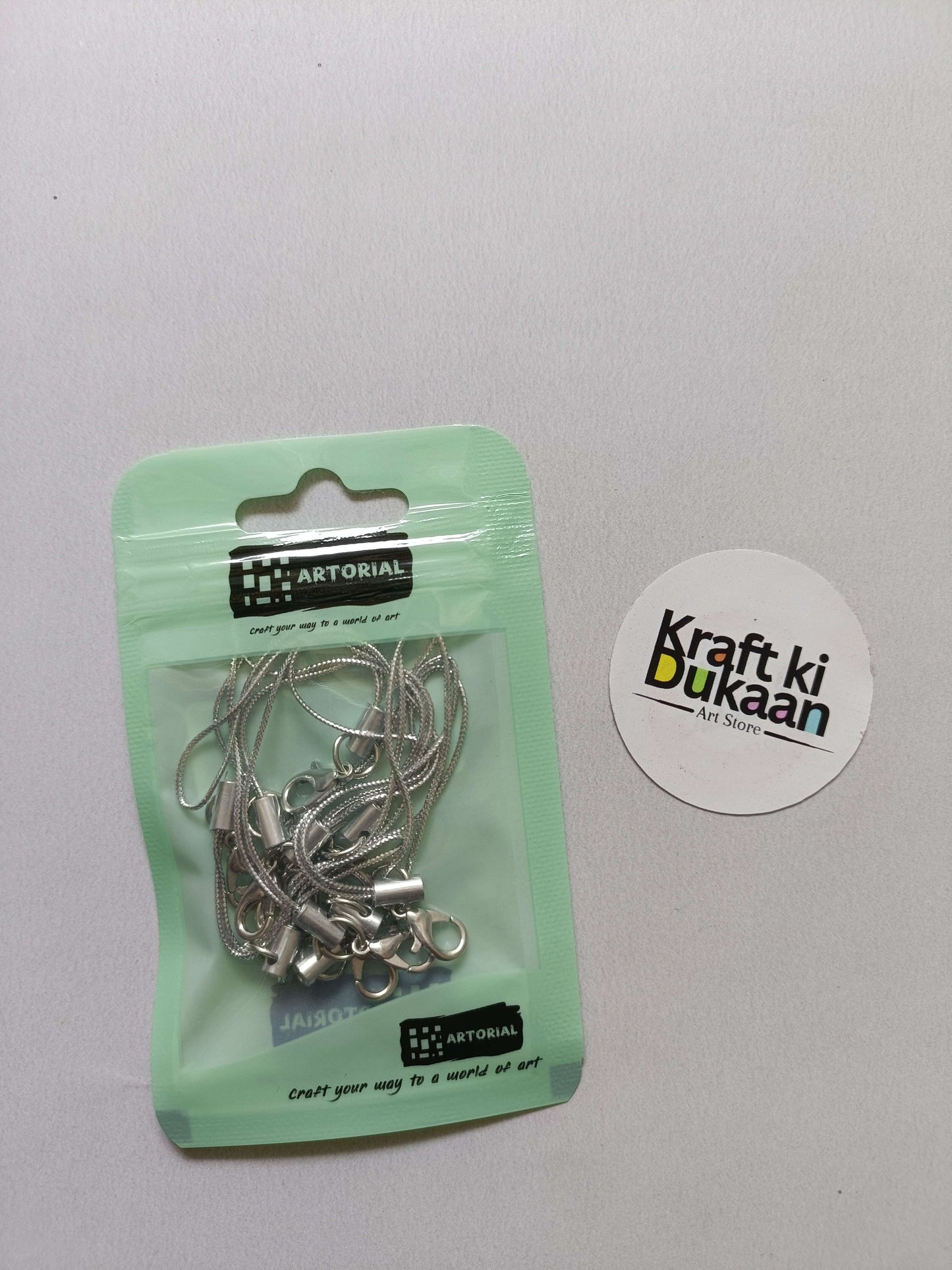 Silver cord keychain set with lobster clasps, metal clips on a card pack.