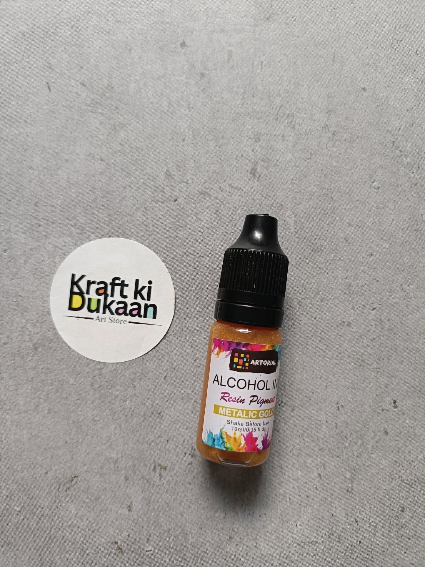 Alcohol ink bottle with black cap, metallic gold resin pigment label