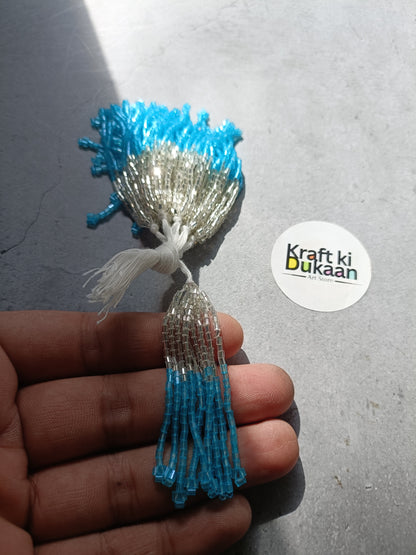 Small beaded tassel latkan with silver top and light blue fringe.