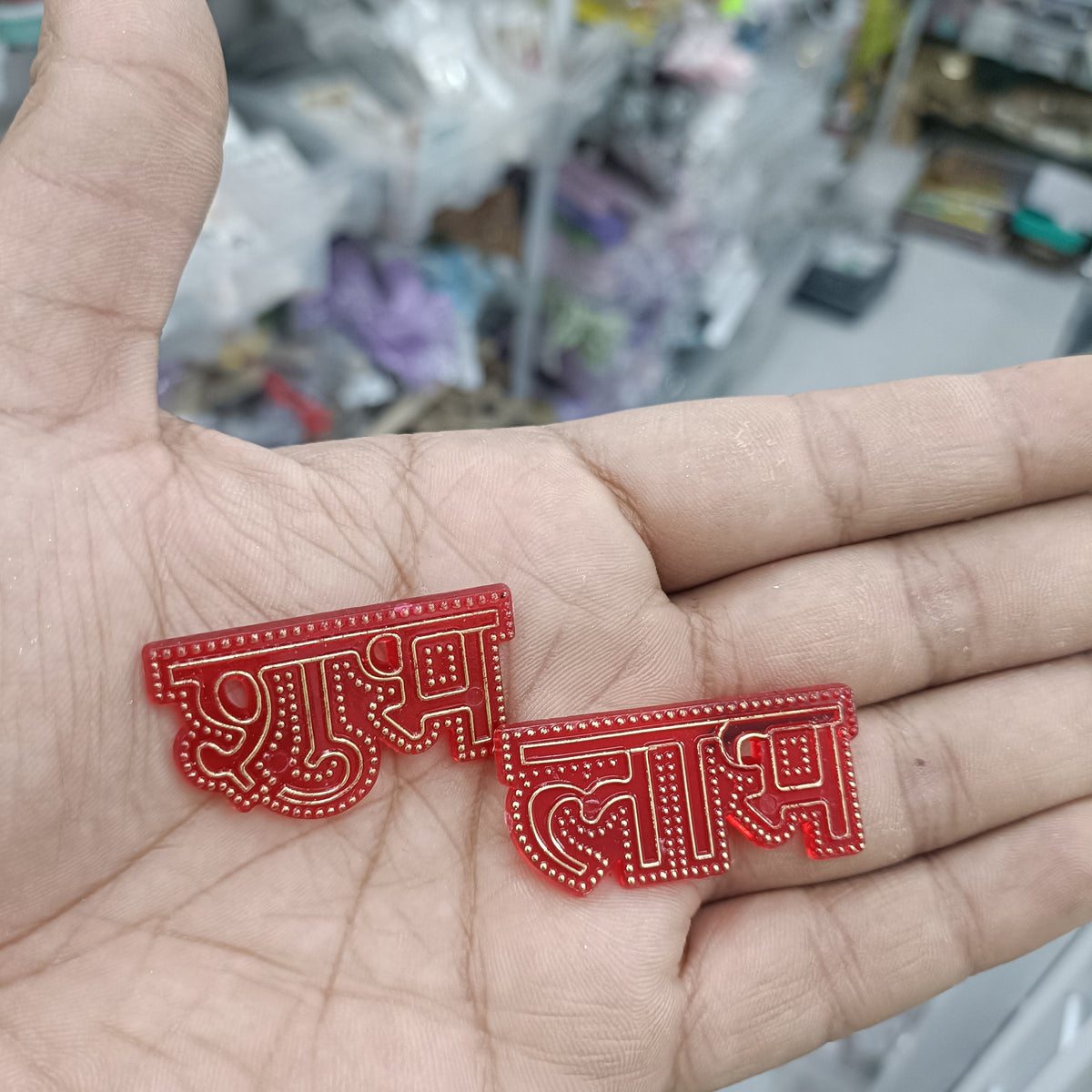 Red acrylic Shubh Labh earrings with ornate cutout design, pair