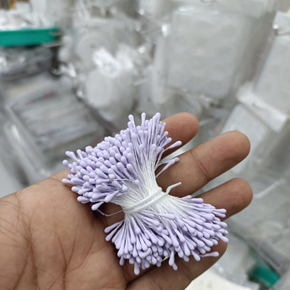 Artificial pollen bunch with light purple bristle flowers tied with white string