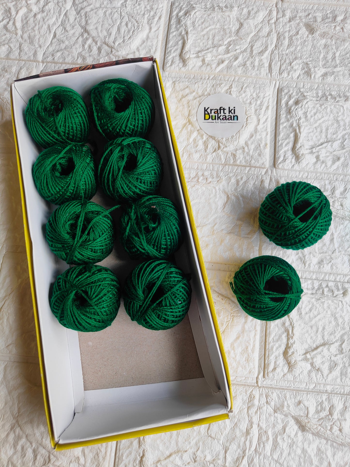 Rakhi thread roll set with green yarn balls in an open cardboard box