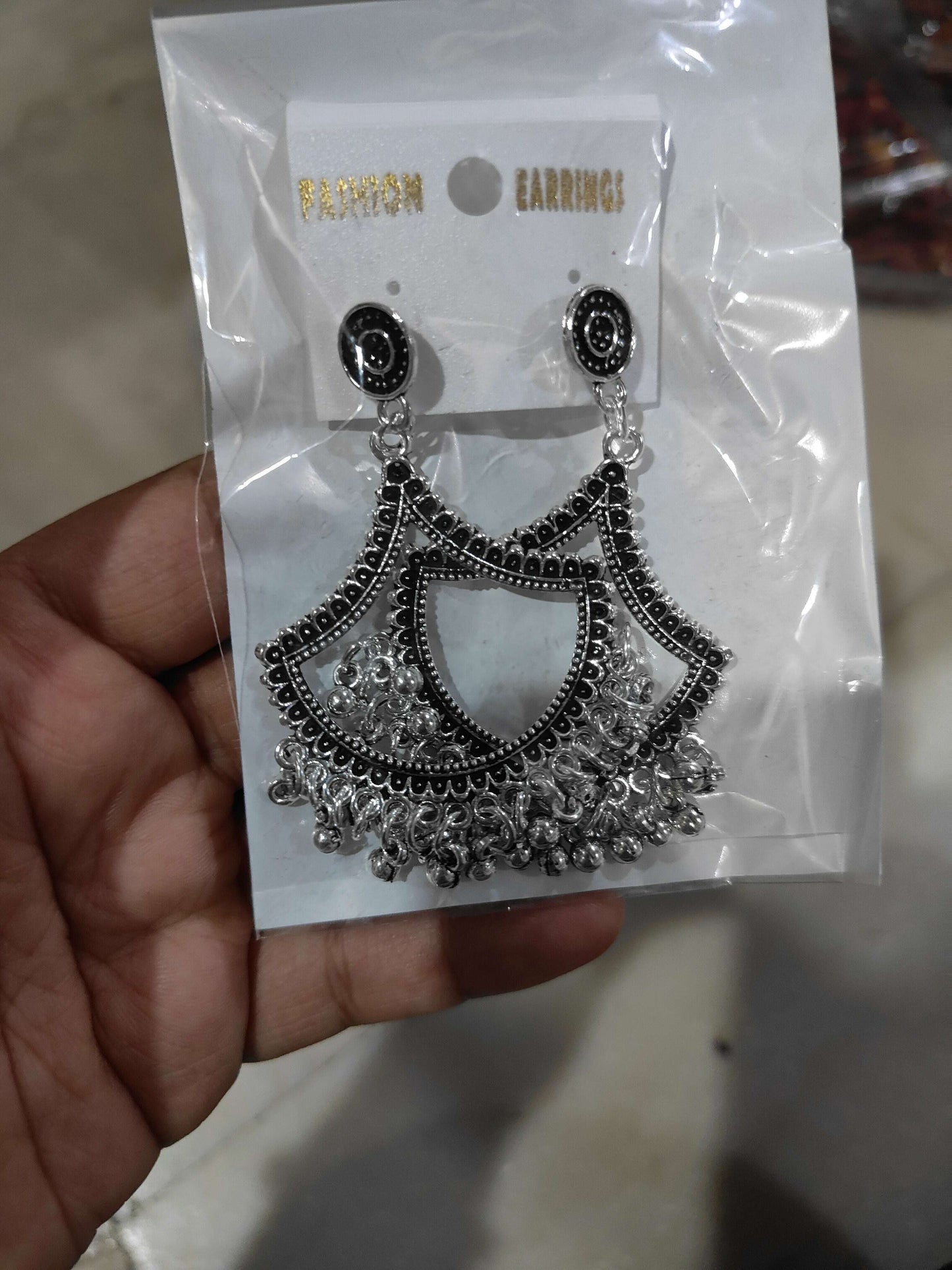 Silver jhumka-style drop earrings with black round tops and fan tassel design