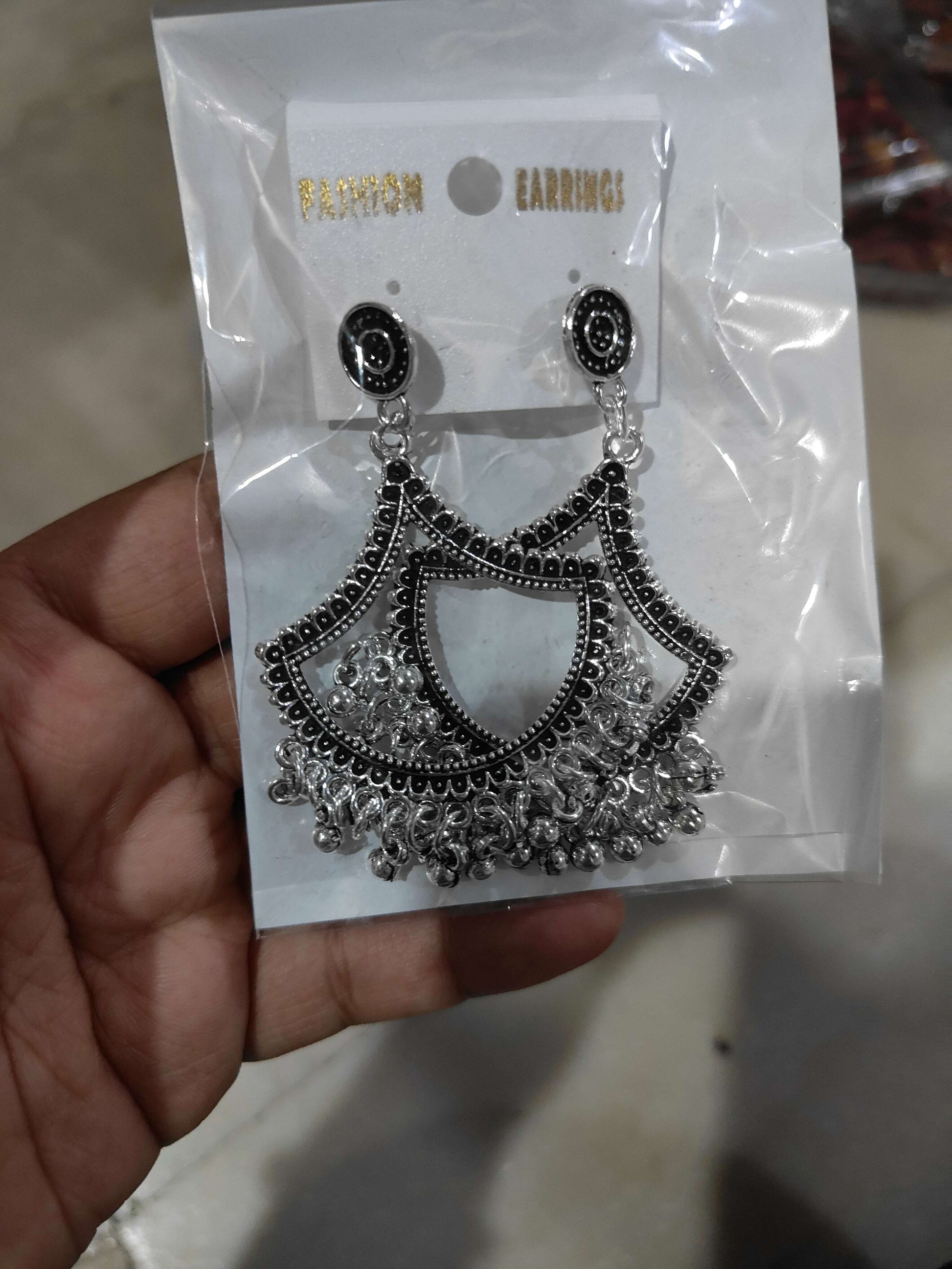 Silver jhumka-style drop earrings with black round tops and fan tassel design