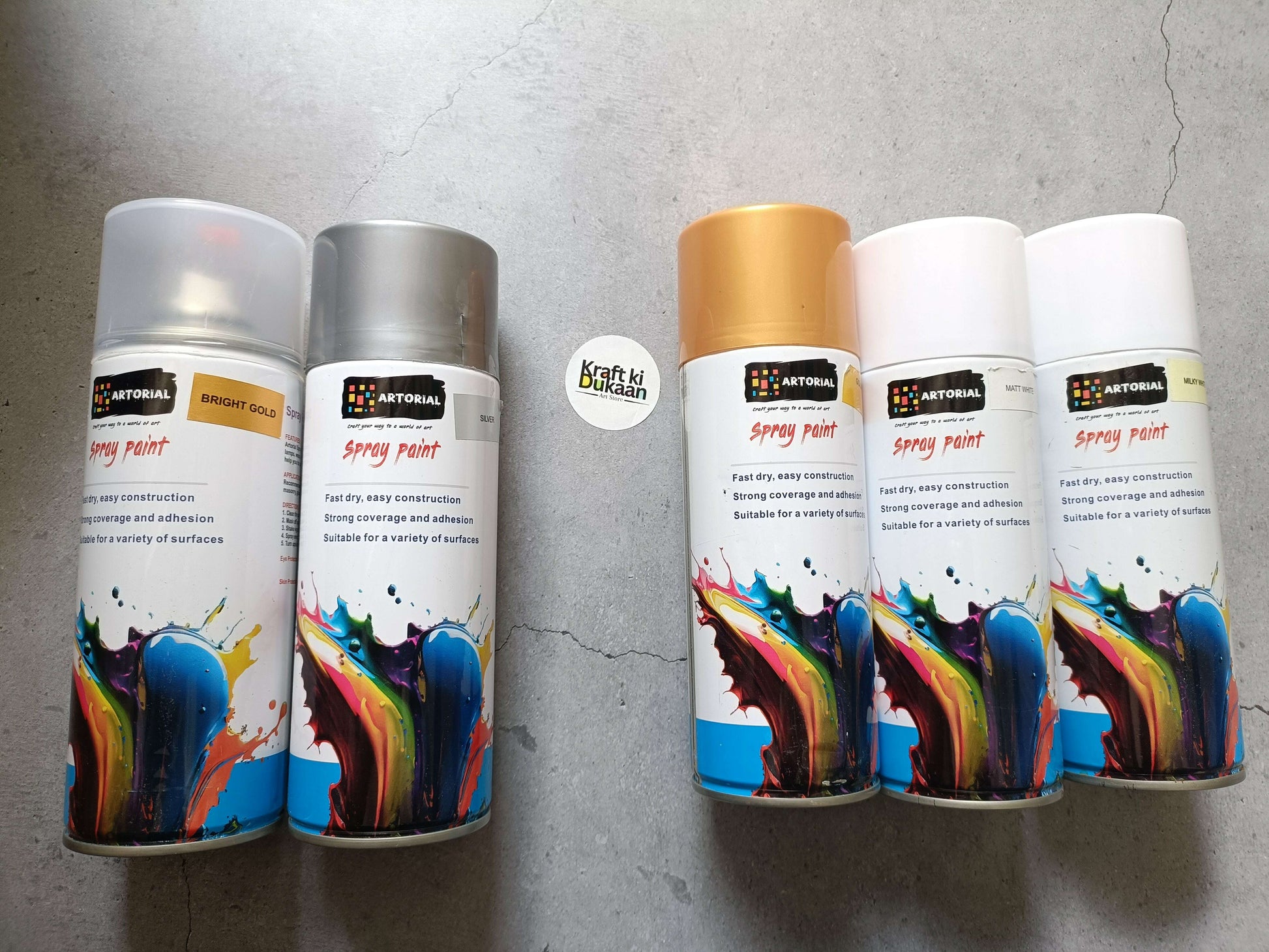 Assorted spray paint cans in bright gold, silver, golden, matt white, and milky white