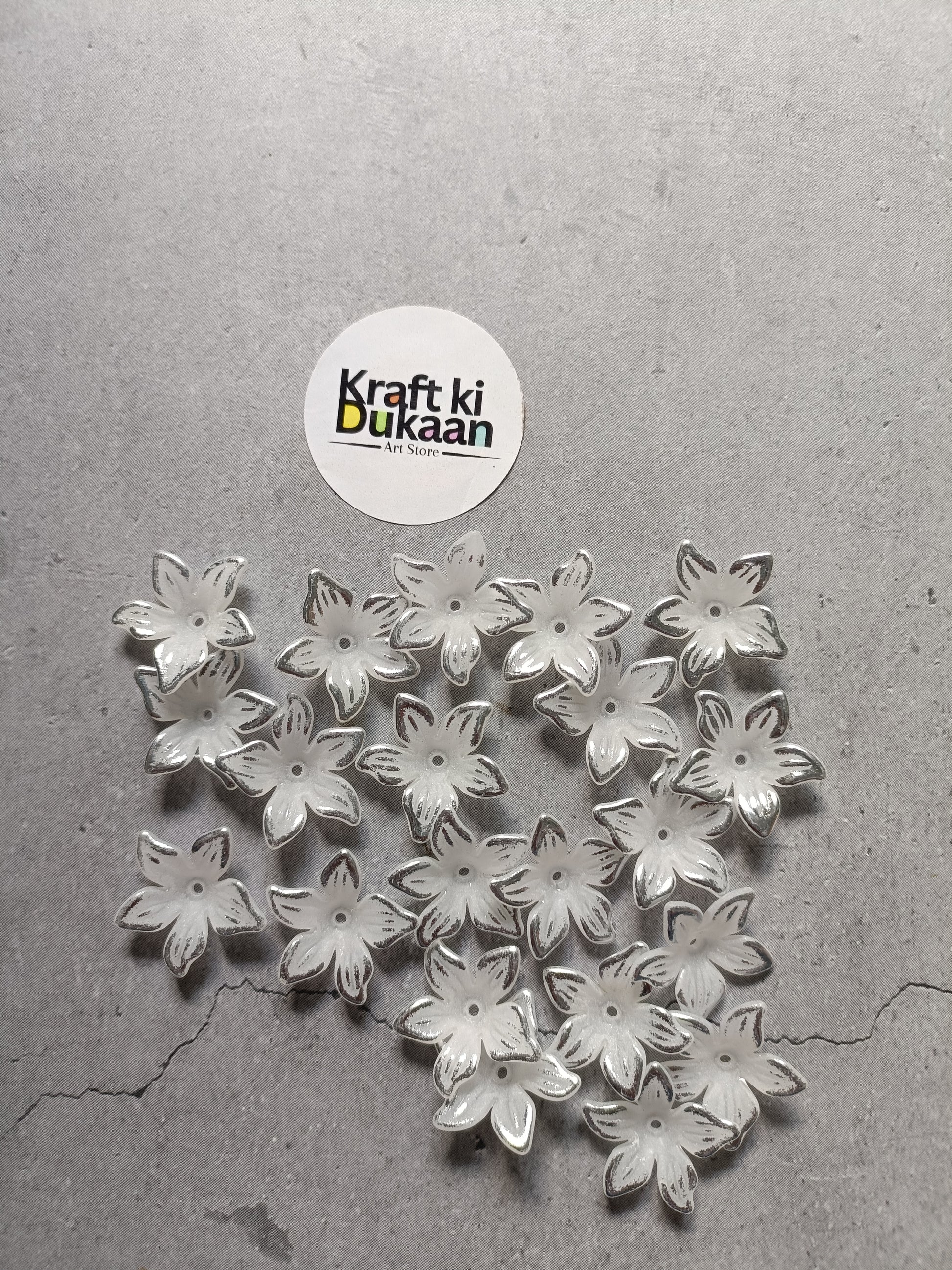 Pile of silver flower-shaped beads with embossed petals on flat back