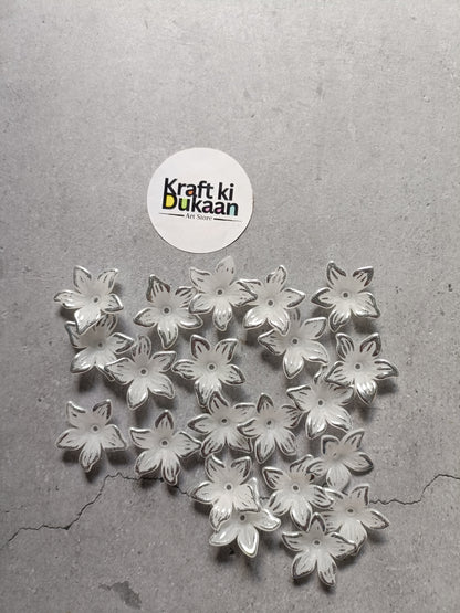 Pile of silver flower-shaped beads with embossed petals on flat back