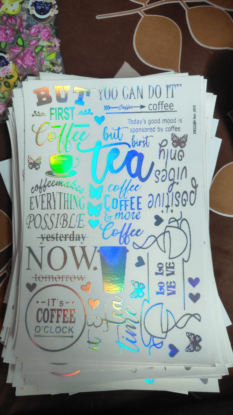 Holographic sticker sheet with coffee-themed words and icons, holographic foil finish.