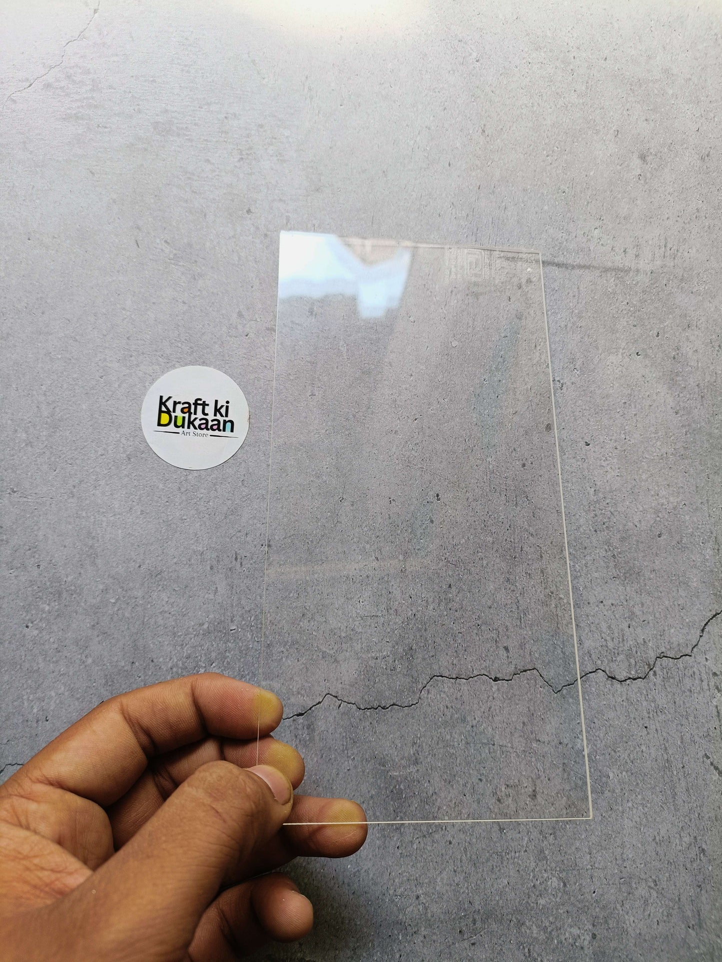 Clear acrylic rectangle sheet with protective film, held by hand
