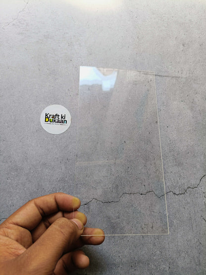 Clear acrylic rectangle sheet with protective film, held by hand