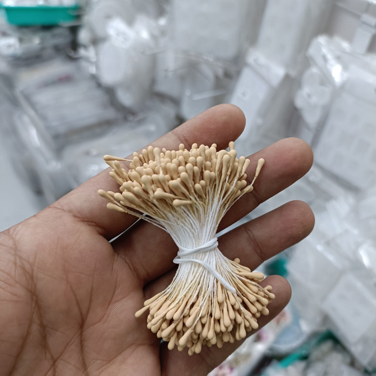Artificial pollen bunch with beige bristle flowers tied with white string