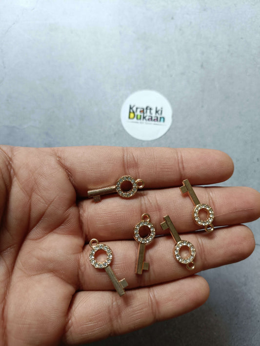 Gold-tone rhinestone key pendant charms set in hand, round crystal ring details