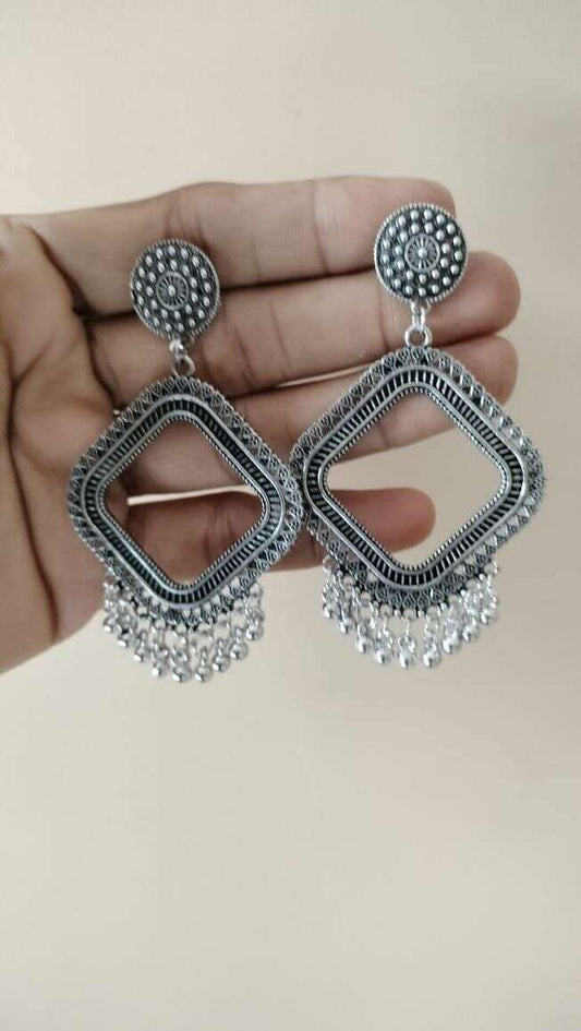 Silver jhumka earrings with textured round tops and dangling metal fringe, no beads