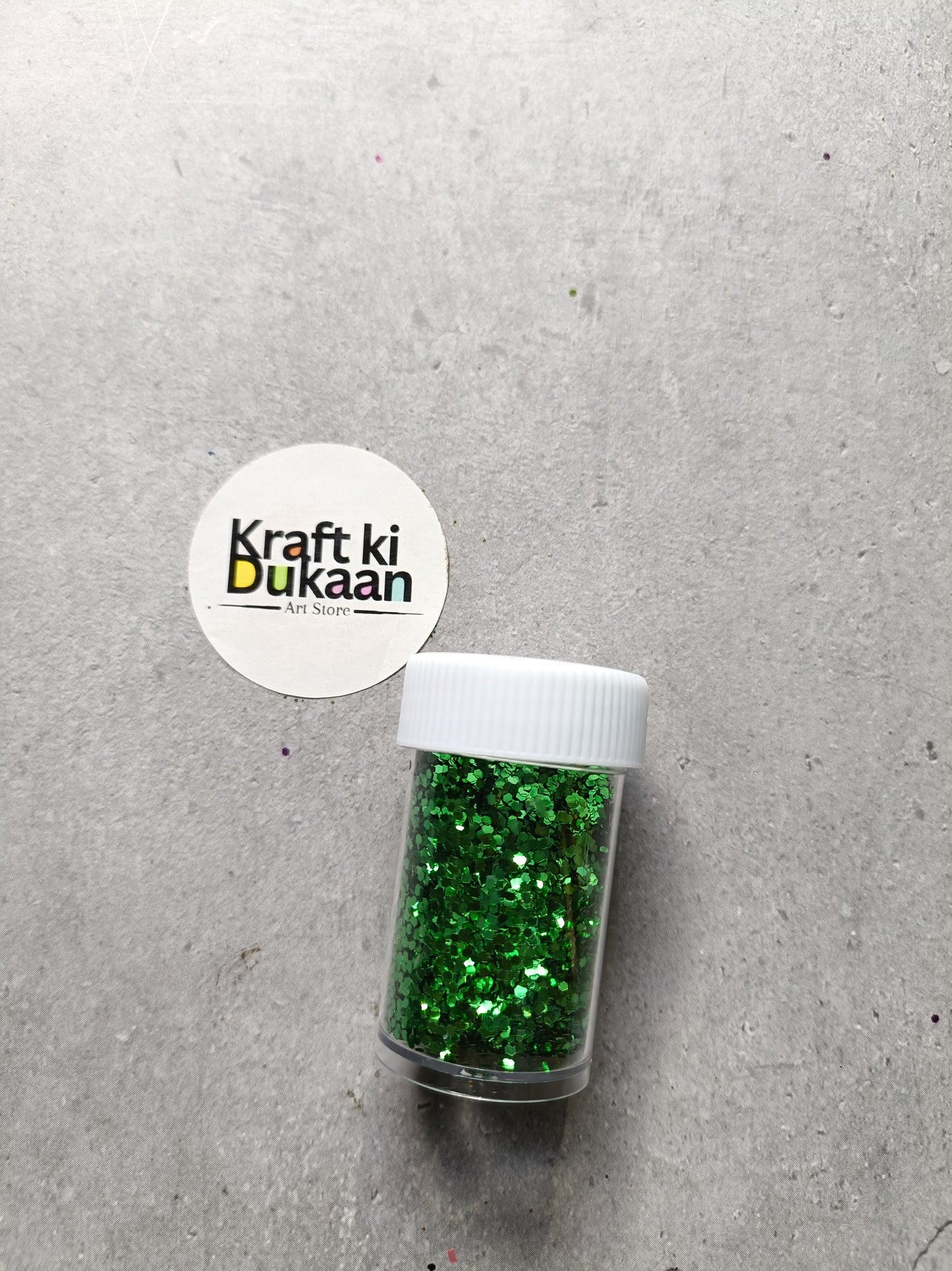 Hexagon glitter jar with green glitter in a small white-lidded bottle
