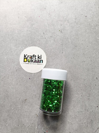 Hexagon glitter jar with green glitter in a small white-lidded bottle