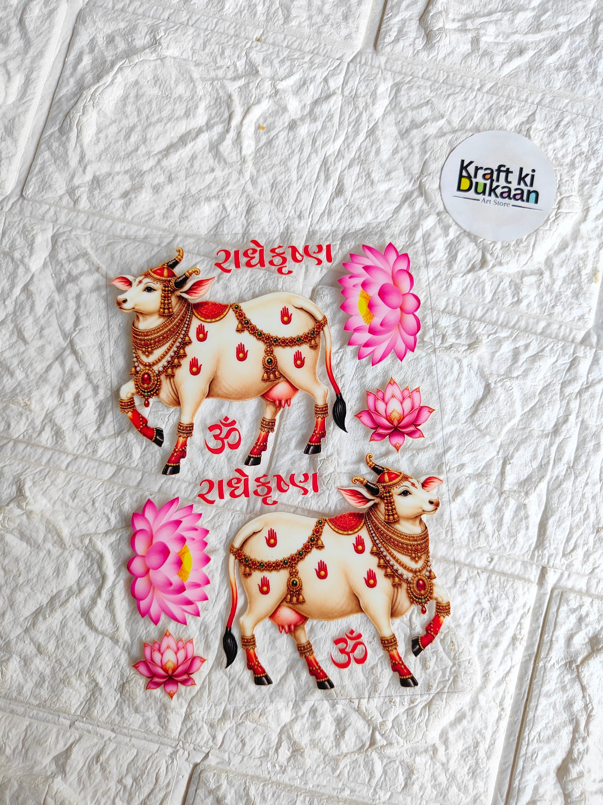 Peel-off sticker sheet with two ornate cow designs, pink flowers, and red decorative accents