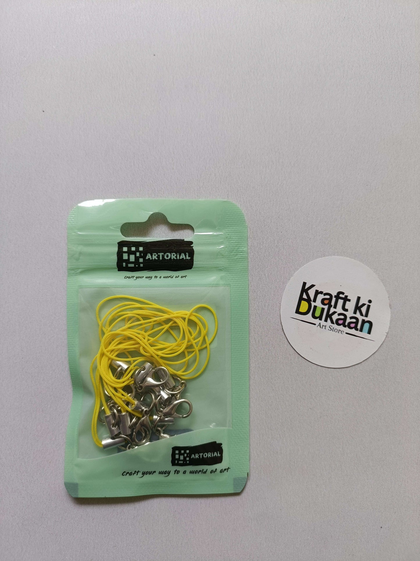 Yellow cord keychain set with lobster clasps, metal clips on a card pack.
