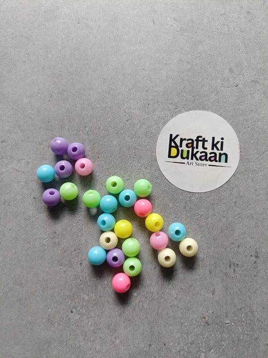 Rakhi bracelet beads pack, multicolor round beads scattered on surface