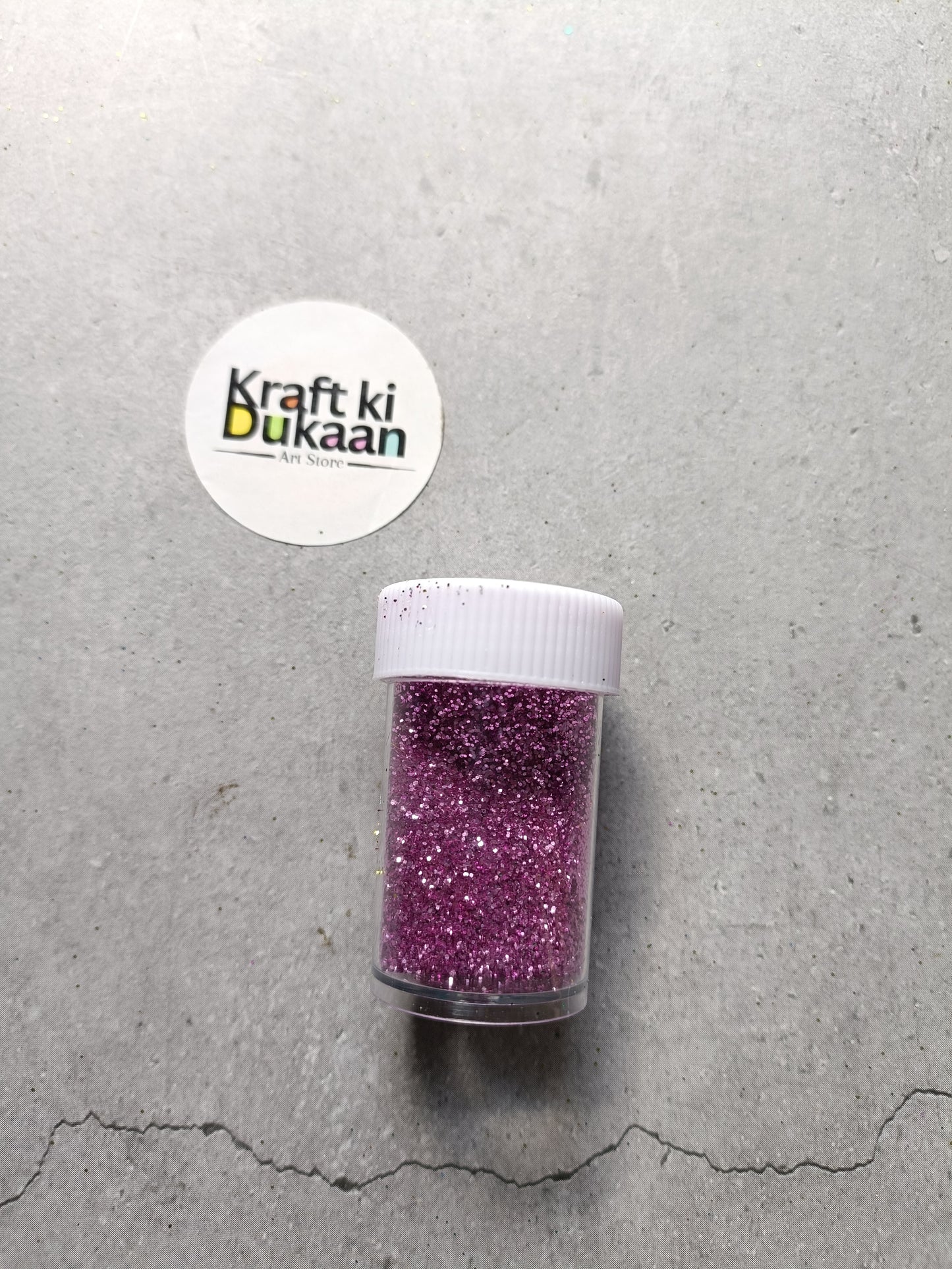 Purple pink chunky glitter powder jar with white lid.