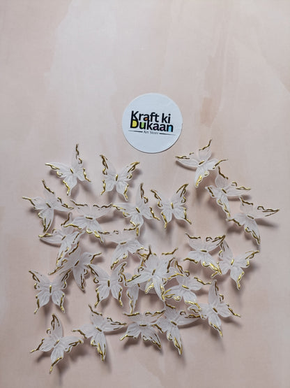 Butterfly bead pack of 25, gold-tone and white butterfly charms laid out