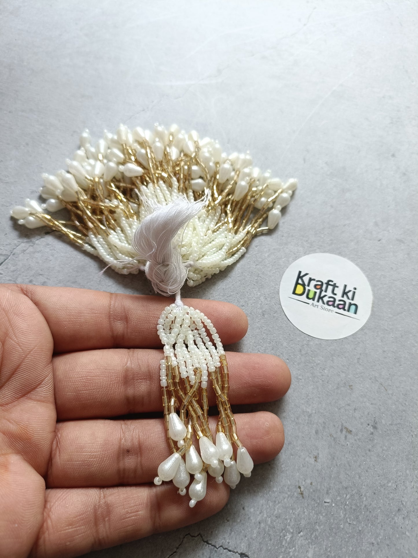 Beaded latkan tassel in gold and white, with braided loop and hanging beads