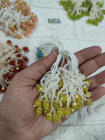 Beaded tassel with white fringe, green and gold dangling beads